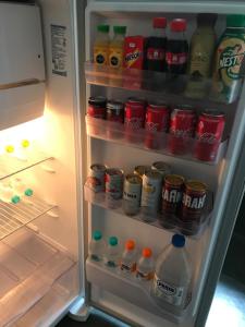 um frigorífico aberto cheio de bebidas e refrigerantes em Casa Aconchego em Itu