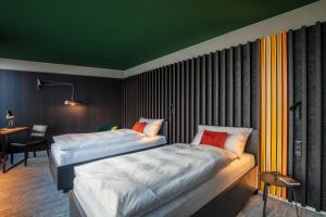 two beds in a room with a green ceiling at Macardo Premium B&B 