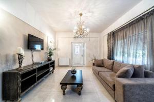 a living room with a couch and a tv at Ioannas Luxury Apartment in Istron in Kalo Chorio