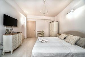 ein Schlafzimmer mit einem großen Bett und einem TV an der Wand in der Unterkunft Ioannas Luxury Apartment in Istron in Kalo Chorio
