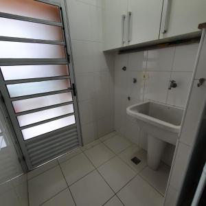 a bathroom with a sink and a shower backdoor at APTO UBATUBA-PRAIA GRANDE-CONDOMÍNIO DUBAI in Ubatuba