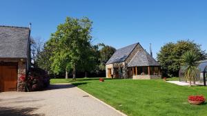 a house with a large grass yard with a building at L Eskemm in Plouaret