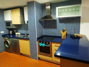 cocina con encimera azul y fogones en Ocean Breeze - Terrace Pools, en Armação de Pêra