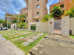 um edifício com um portão em frente a um edifício em Apartamento amplio en zona ideal a 5min de WALLMART em Cancún