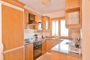 kuchnia z drewnianymi szafkami i zlewem w obiekcie Vivienda Vacacional Radi w mieście Breña Baja