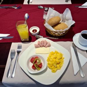 einen Tisch mit einem Teller mit Eiern und Obst in der Unterkunft Hotel Santiago de Compostella Suites in Cuenca
