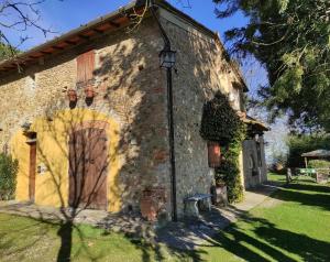 an old stone building with a large wooden door at Podere Casanova in Montespertoli