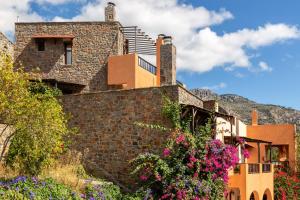 a stone house with flowers in front of it at Mala Villa in Malles