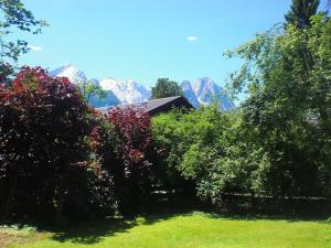 a house with trees and mountains in the background at Ferienwohnung Angie in Garmisch-Partenkirchen