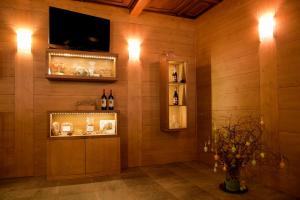 a room with a wall with a tv and some bottles of wine at Hotel La Rosa in Teglio