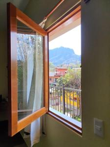 a window with a view of a mountain at Artesanos 11 by Rotamundos in Tepoztlán
