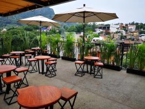 a group of tables and chairs with umbrellas on a patio at Artesanos 11 by Rotamundos in Tepoztlán