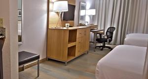 a hotel room with a bed and a desk and a bedroom at Holiday Inn Manahawkin/Long Beach Island, an IHG Hotel in Manahawkin