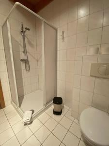 ein Bad mit einer Dusche und einem WC in der Unterkunft Störitzland Betriebsgesellschaft mbH in Grünheide