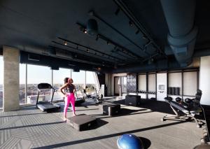 una mujer parada en un gimnasio con equipamiento de ejercicio en Reverb by Hard Rock Atlanta Downtown en Atlanta