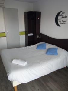 1 cama blanca grande con almohadas azules en una habitación en Couett' Hotel Rumilly en Rumilly