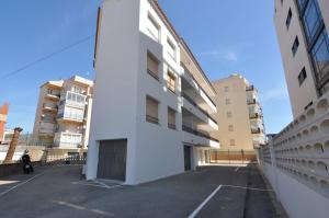 een lege parkeerplaats voor een wit gebouw bij RNET - MTA Apartaments A3 in Roses