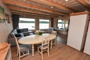 a dining room and living room with a table and chairs at Vila LATO, Druskininkai in Latežeris
