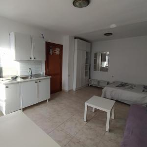 cocina y sala de estar con cama y lavamanos en Casa Luisa, en Caleta de Fuste