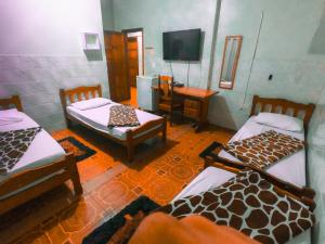 Guajará Palace Hotel في بوتو فيلهو: غرفة بثلاث اسرة وتلفزيون بشاشة مسطحة