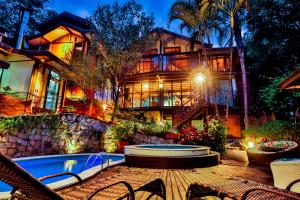 uma casa grande com uma piscina na frente em Templo Do Ser em Ilhabela