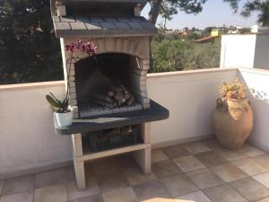 einen Holzofen im Freien auf einer Terrasse in der Unterkunft Villa nel Salento - Casa Maria e Casa Glory in Porto Cesareo