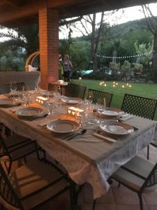 een lange tafel met borden en glazen erop bij Dimorra Country House in Castelvenere
