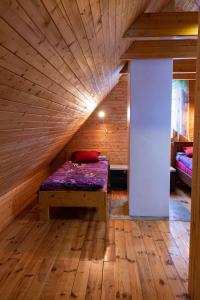 Cama en habitación con techo de madera en Mesikamäe Saunamaja, en Põlva