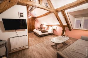 Un dormitorio con una cama y un televisor en una habitación. en La Brocherie, en Magny-le-Désert