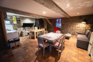 a kitchen and a living room with a table and chairs at La Brocherie in Magny-le-Désert