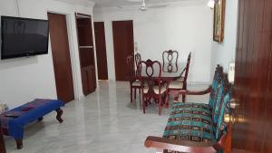 a living room with a table and chairs and a tv at Casa amueblada - Mazatlán in Mazatlán