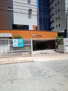 una cerca blanca frente a un edificio en Apto. 100m da feirinha da beira mar, en Fortaleza