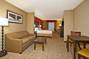 a hotel room with a bed and a living room at Holiday Inn Express & Suites Springfield by IHG in Springfield +23 photos