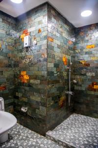 a bathroom with a shower with a stone wall at Bays Boutique Apartment in Accra +174 photos
