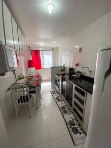 a kitchen with a sink and a table in it at Residencial Lagomar, sol e mar para relaxar! in Saquarema