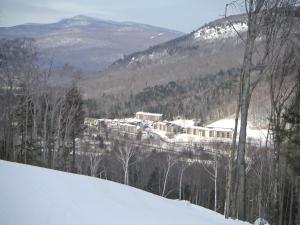 einen schneebedeckten Berg mit einer Stadt in der Ferne in der Unterkunft InnSeason Resorts Pollard Brook in Lincoln