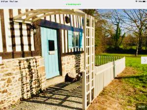 einen weißen Zaun mit blauer Tür auf einem Haus in der Unterkunft Maison Mai or La Petite Maison Mai or La Petite Grange or ALL three in La Chapelle-Urée