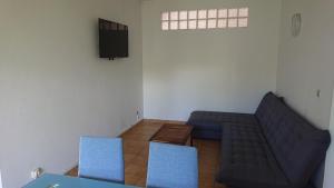 ein Wohnzimmer mit einem Sofa und zwei blauen Stühlen in der Unterkunft Bas de villa 80m2 entrée et jardin privés à 500 metres de la plage in Sainte-Anne