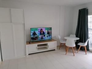 uma sala de estar com uma televisão e uma mesa com cadeiras em AVENIDA DELUXE CANDELARIA em Candelaria