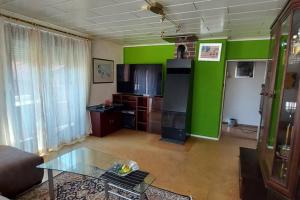 salon ze szklanym stołem i zielonymi ścianami w obiekcie Quiet apartment close to town w Villach