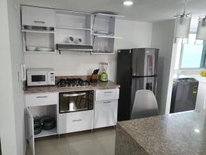 a kitchen with a stove and a refrigerator at Excelente Apartamento Completo, en la mejor zona in Cúcuta