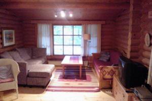 a living room with a couch and a table at Holiday Cabin Kerimaa 121 in Savonlinna