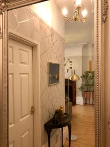 a mirror reflecting a hallway with a table and a room at Ann Apartments opposite the Pier with sea view in Portsmouth