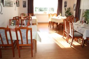 un comedor con mesas y sillas y una ventana en Landhaus Riedel en Papenburg