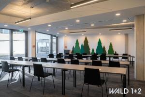 uma grande sala com mesas e cadeiras e árvores de Natal em das flax allgäu em Dietmannsried