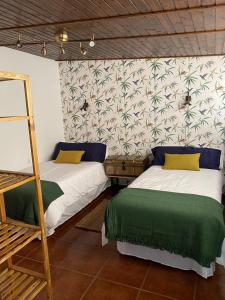 two beds in a room with a wall at Old Town House La Laguna in Las Lagunas