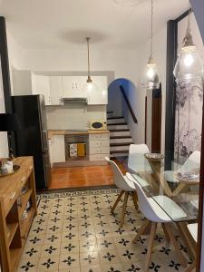 a kitchen with a glass table and white cabinets at Old Town House La Laguna in Las Lagunas