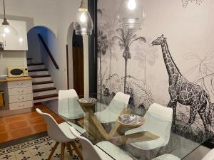 a dining room with a glass table and a giraffe mural at Old Town House La Laguna in Las Lagunas