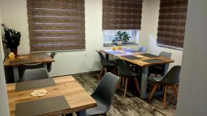 Gostynna Rodyna في إزكي: غرفة طعام مع طاولات وكراسي خشبية