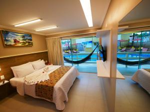 una habitación de hotel con una cama y una hamaca en Pousada Recanto dos Corais, en Porto de Galinhas
